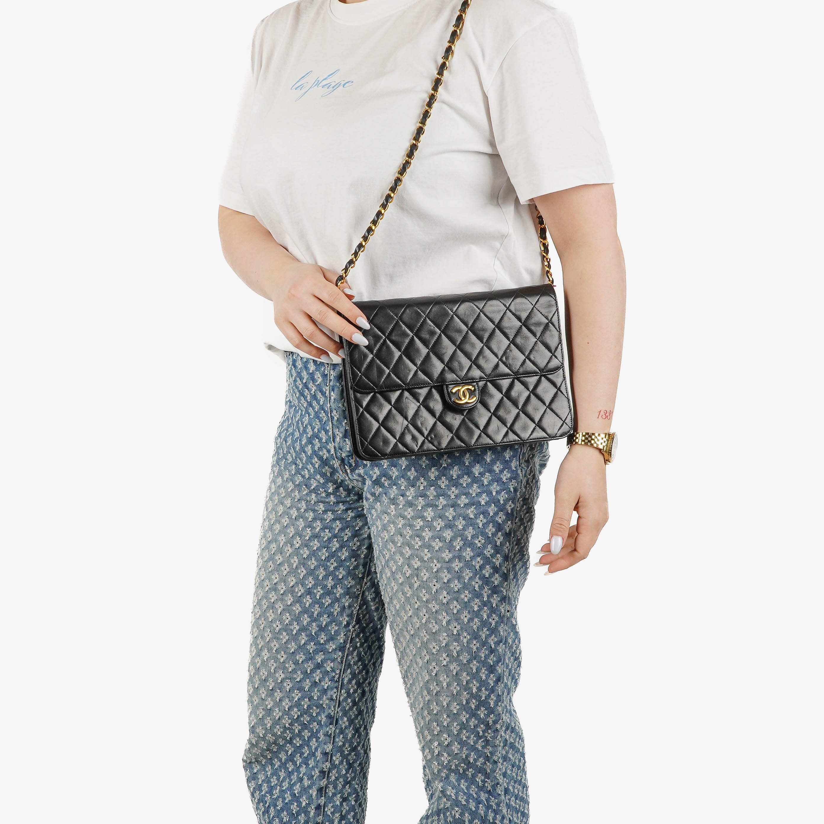 Sac à rabat unique classique moyen Chanel en agneau matelassé noir avec ferrures plaquées or 24K